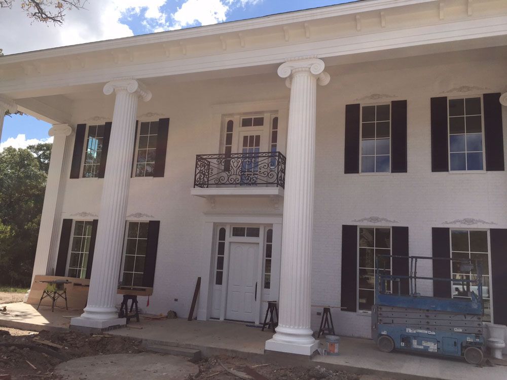 A large white house with black shutters and columns