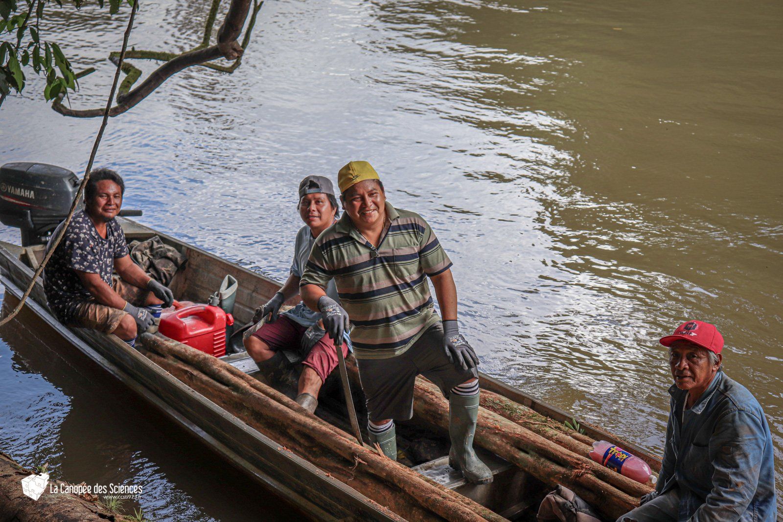 Un groupe d'hommes sont assis dans un bateau sur une rivière.