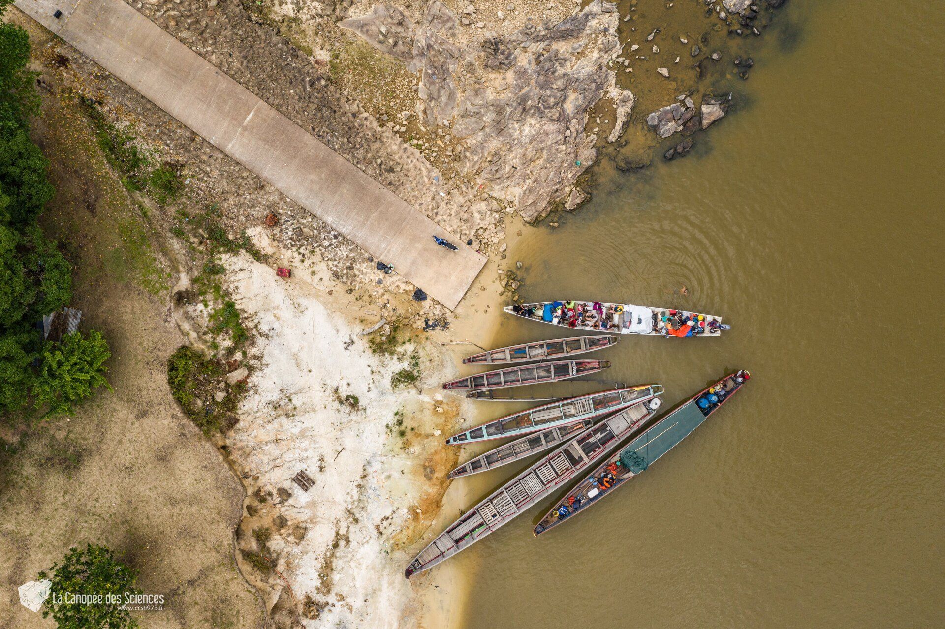 Un groupe de bateaux est assis sur la rive d'une rivière.