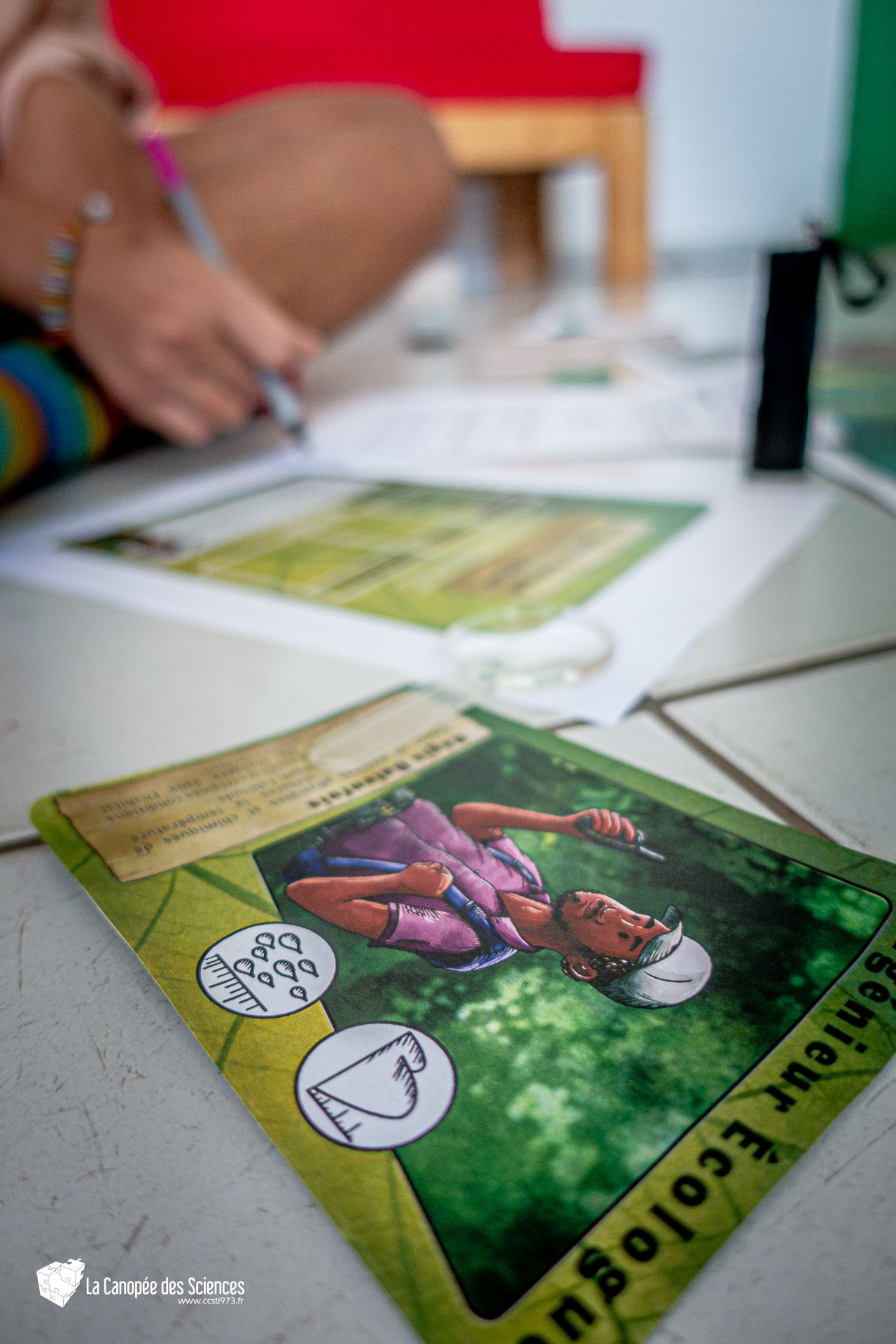 Une personne écrit sur un morceau de papier à côté d'un livre.