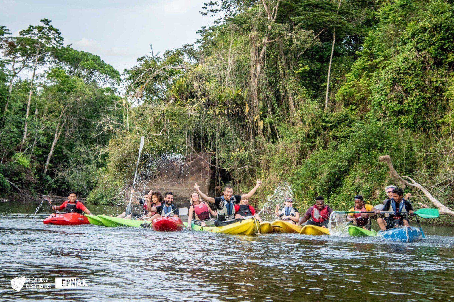 Un groupe de personnes rame en kayak sur une rivière.