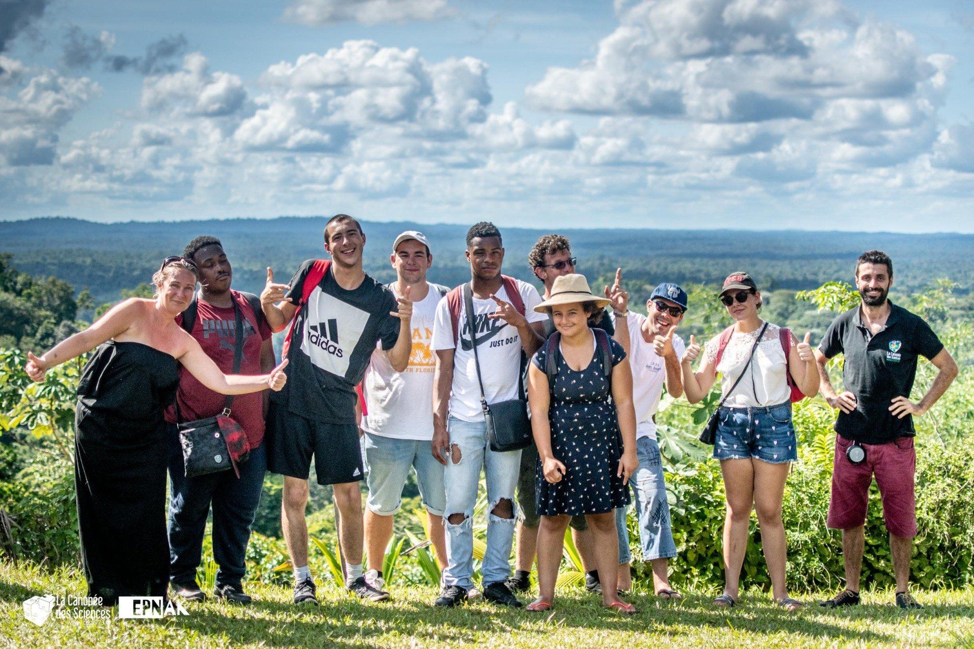 Un groupe de personnes pose pour une photo au sommet d'une colline.
