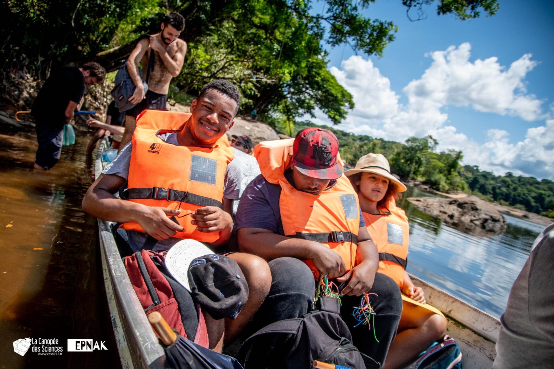 Un groupe de personnes est assis dans un bateau sur une rivière.