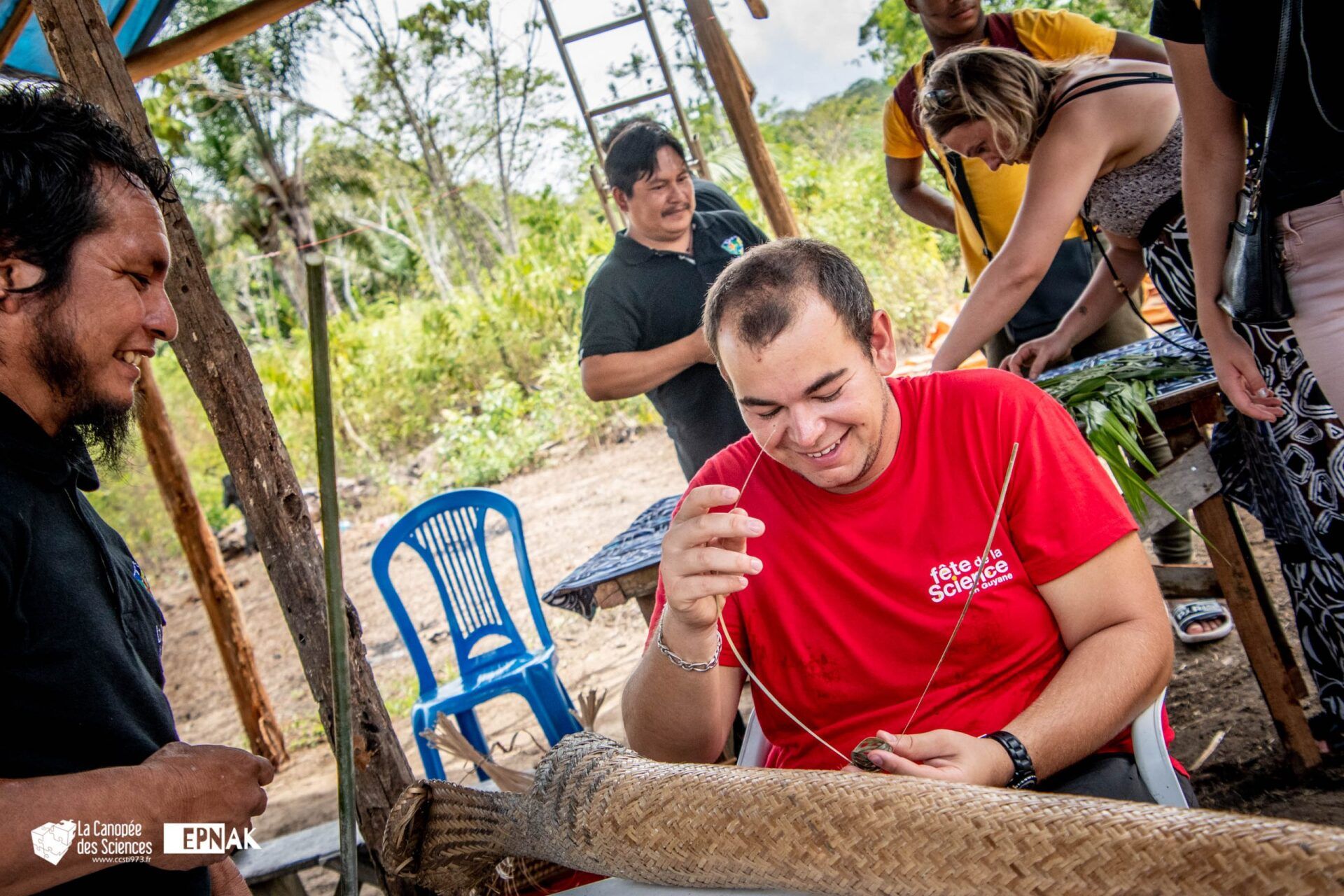 Un groupe de personnes se tient autour d'un homme en chemise rouge.