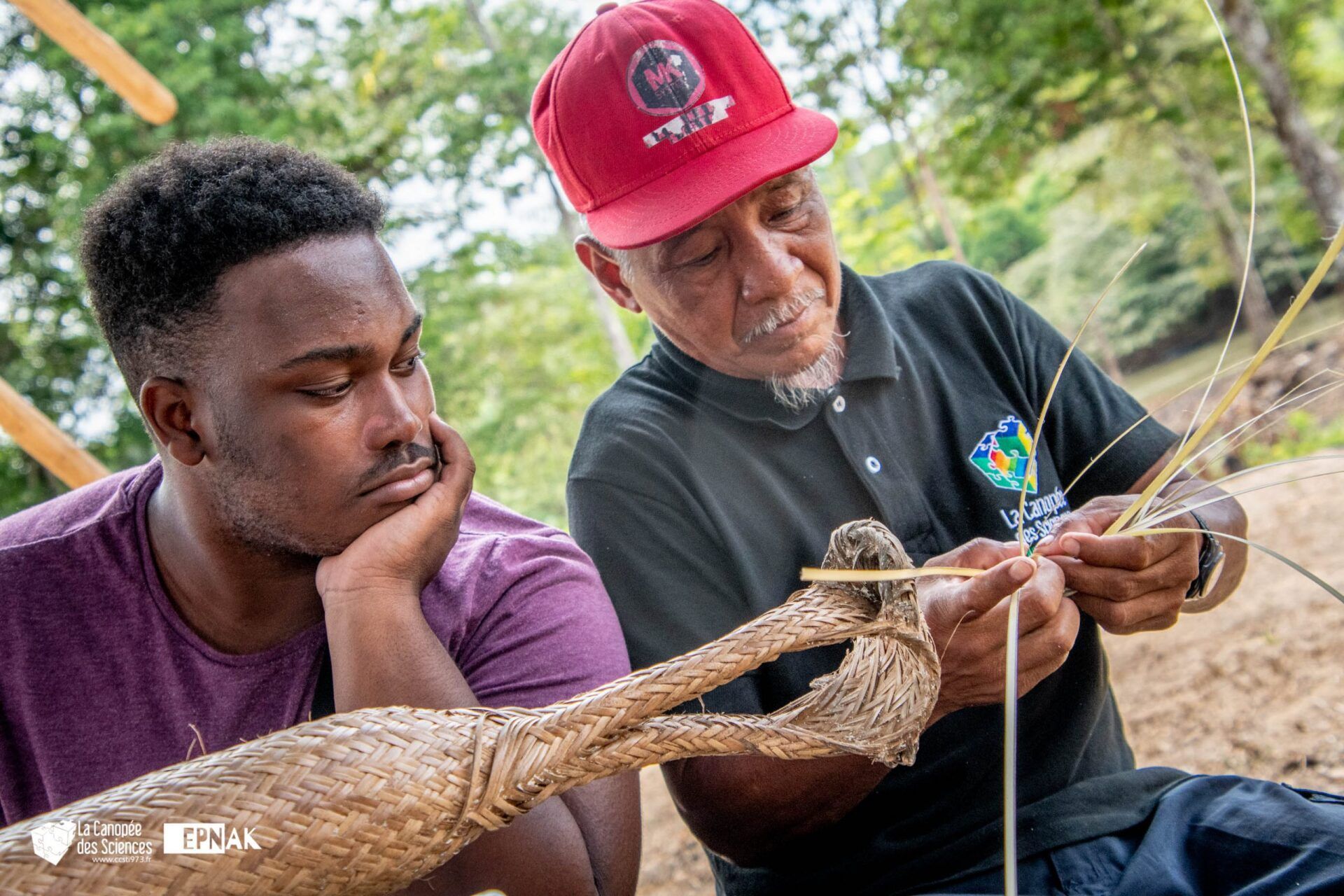 Deux hommes sont assis l'un à côté de l'autre et travaillent sur une sculpture.