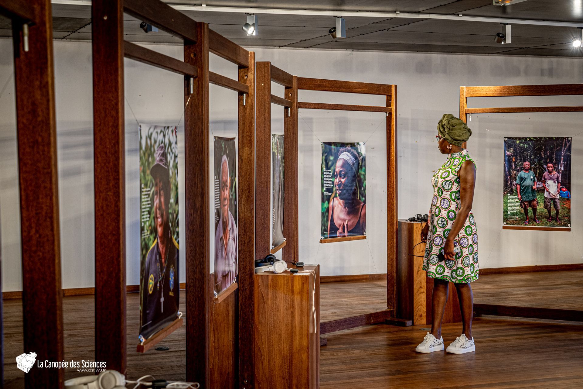 Une femme se tient debout dans un musée et regarde des peintures.