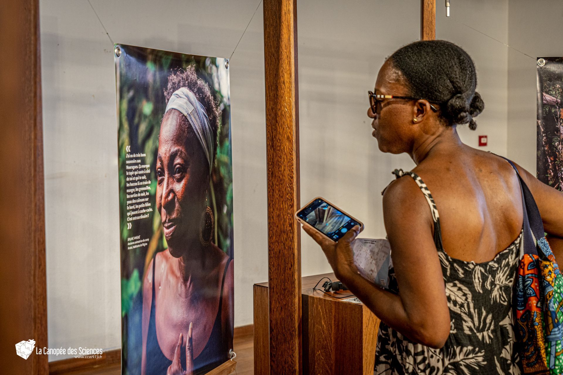 Une femme regarde une photo d'une femme dans un musée.