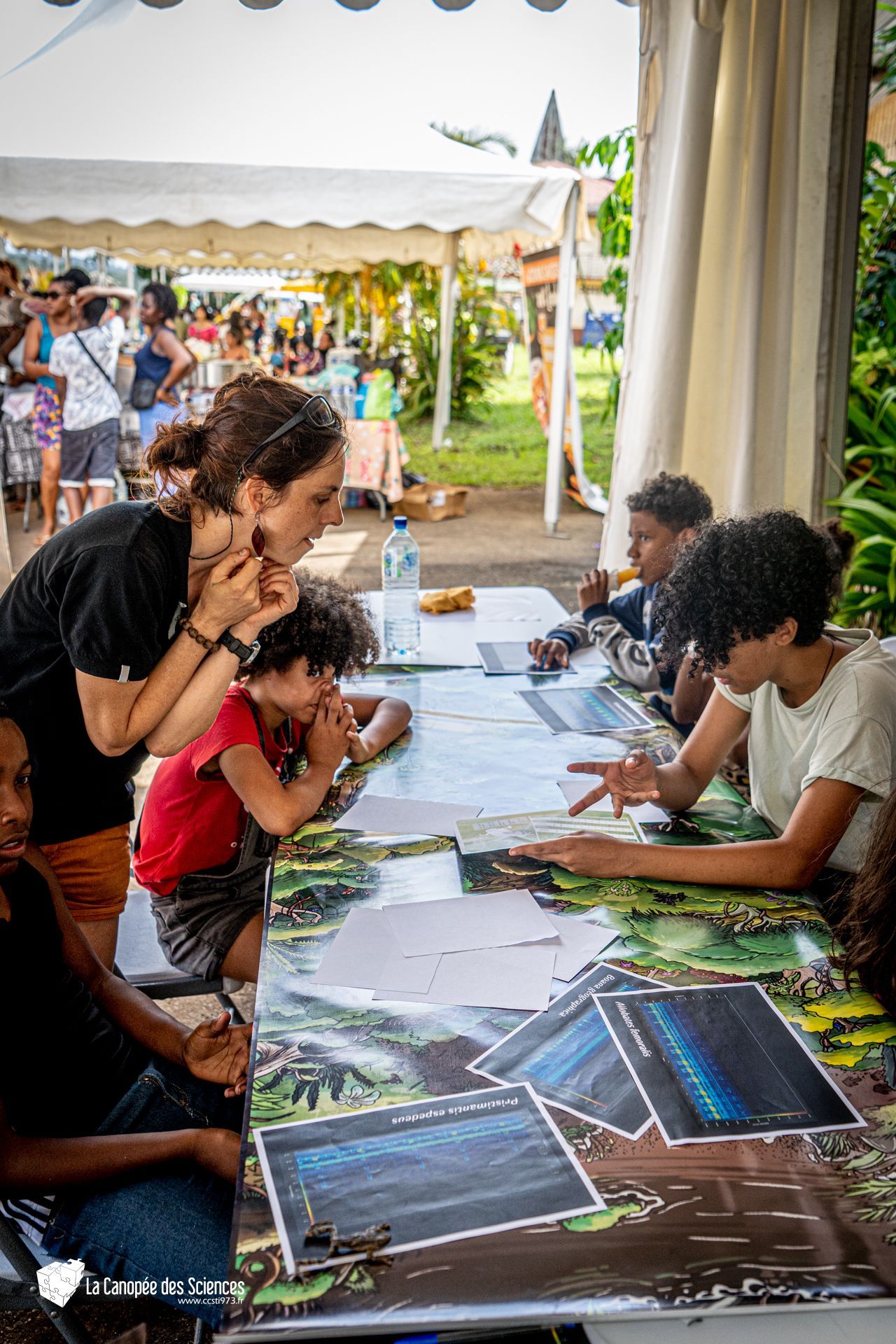 Un groupe de personnes est assis autour d'une table et regarde des photos.