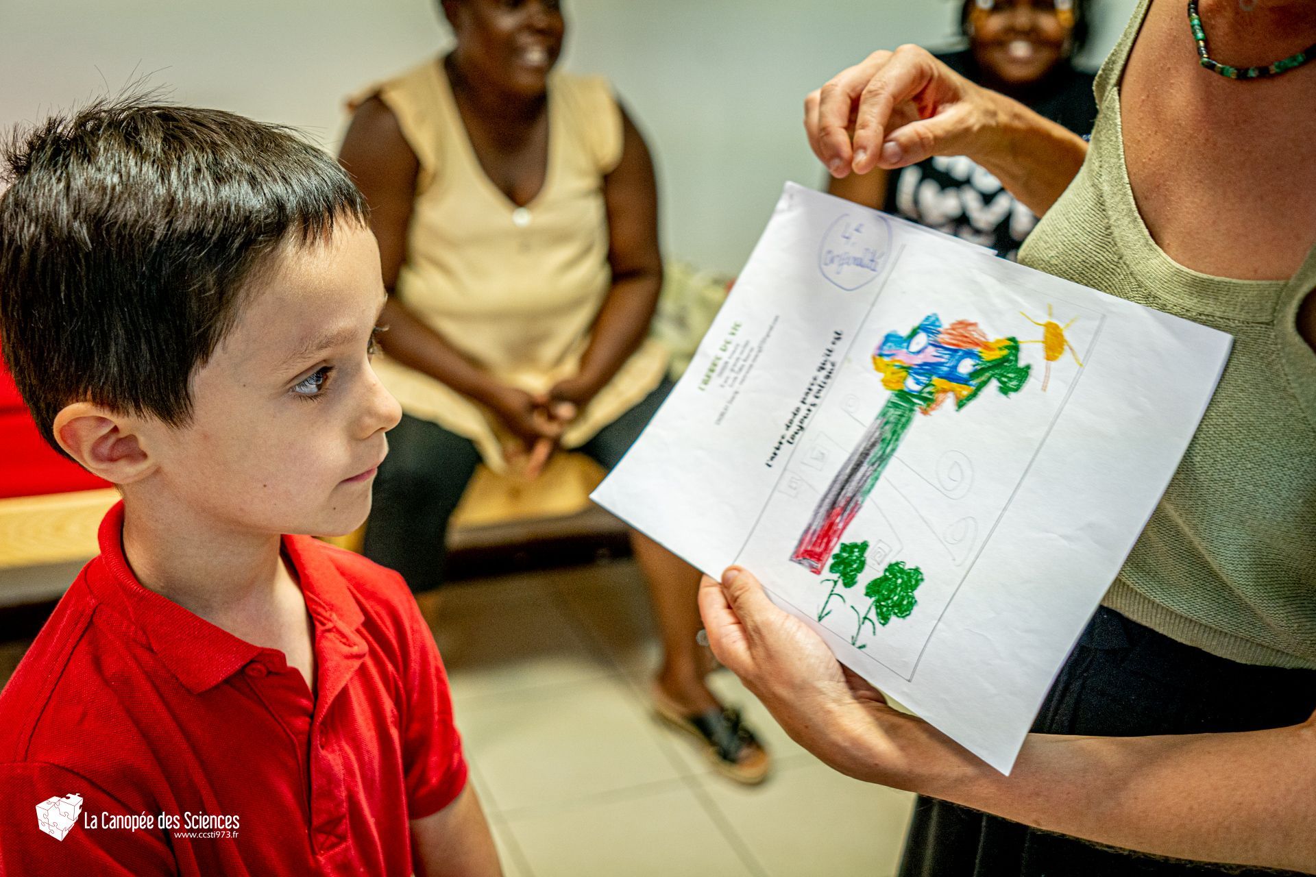 Une femme tient un morceau de papier avec le dessin d'une clé dessus.