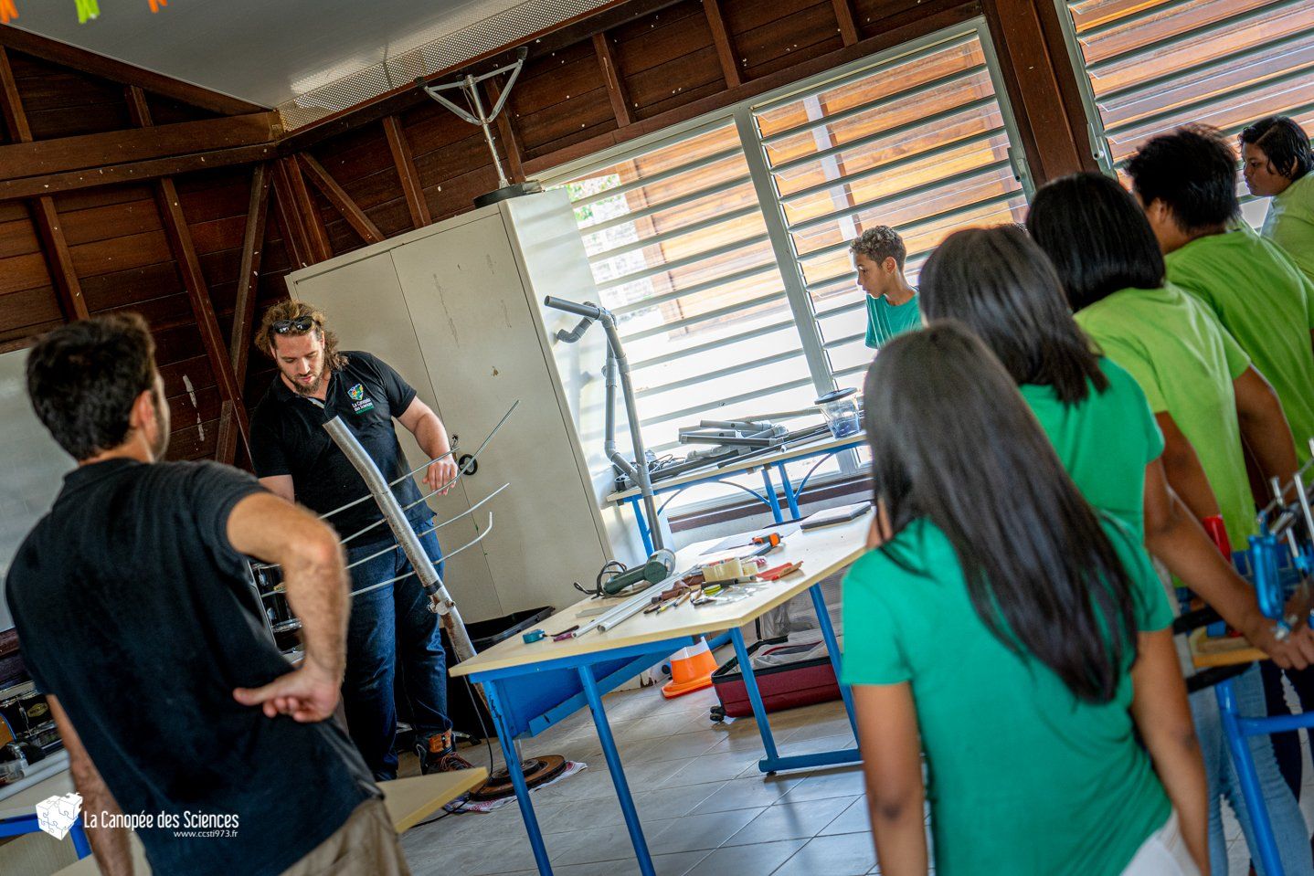 Un groupe de personnes se tient autour d'une table dans une pièce.