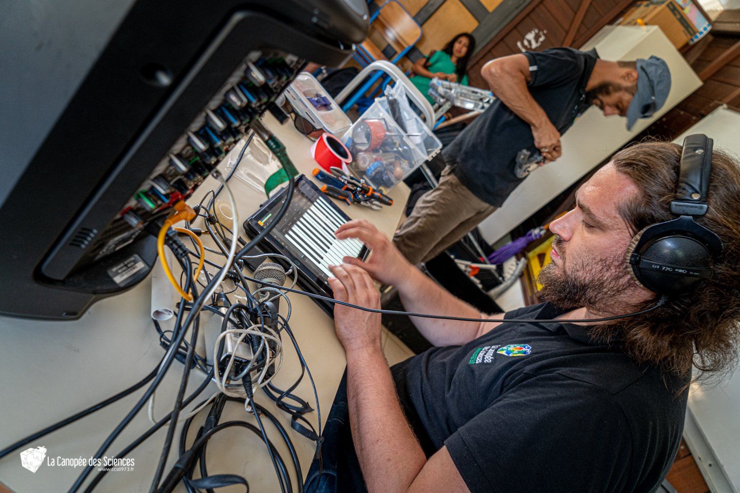 Un homme portant des écouteurs travaille sur un ordinateur portable.