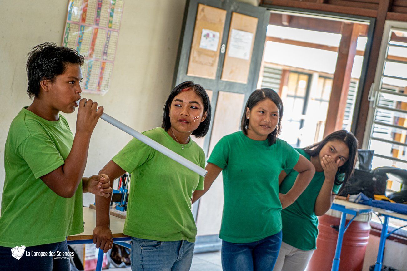 Un groupe de jeunes filles en chemises vertes se tiennent dans une pièce.
