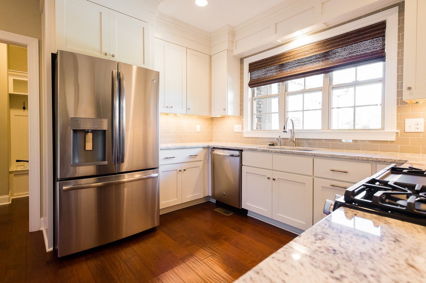 A kitchen with stainless steel appliances and white cabinets.