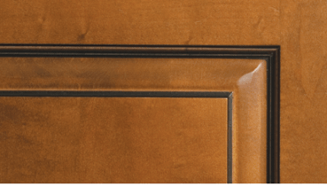 A close up of a wooden door with a black trim.