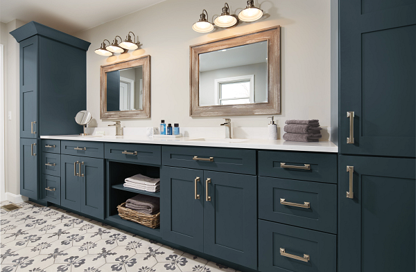 A bathroom with two sinks , two mirrors , and blue cabinets.