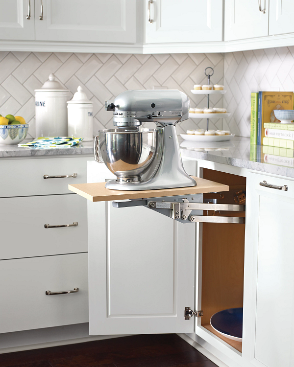 A kitchen with white cabinets and a mixer on a shelf