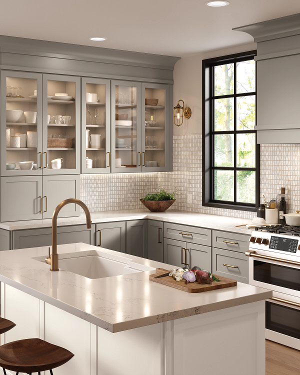 A kitchen with a large island , sink , stove and window.