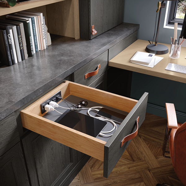 A desk with a drawer open with a tablet in it