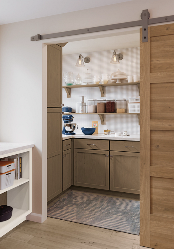 A kitchen with a sliding barn door leading to a pantry.