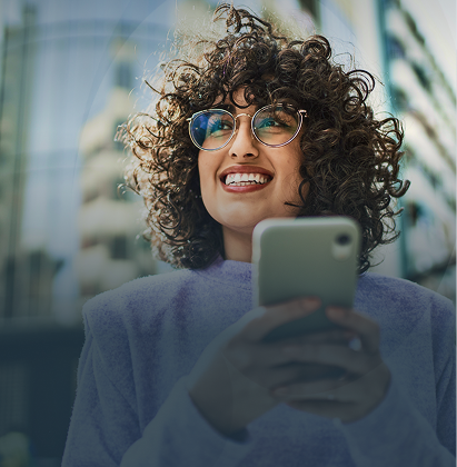 Mulher de camisa verde sorrindo enquanto usa um telefone; logotipo do Unicredit no canto.