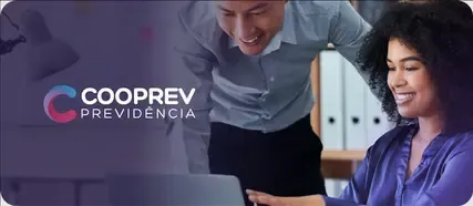 Dois colegas sorriem enquanto olham para a tela de um laptop. Um está de pé, o outro sentado.