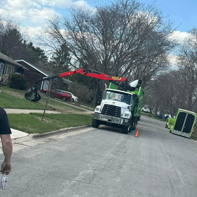 A garbage truck is parked on the side of the road.