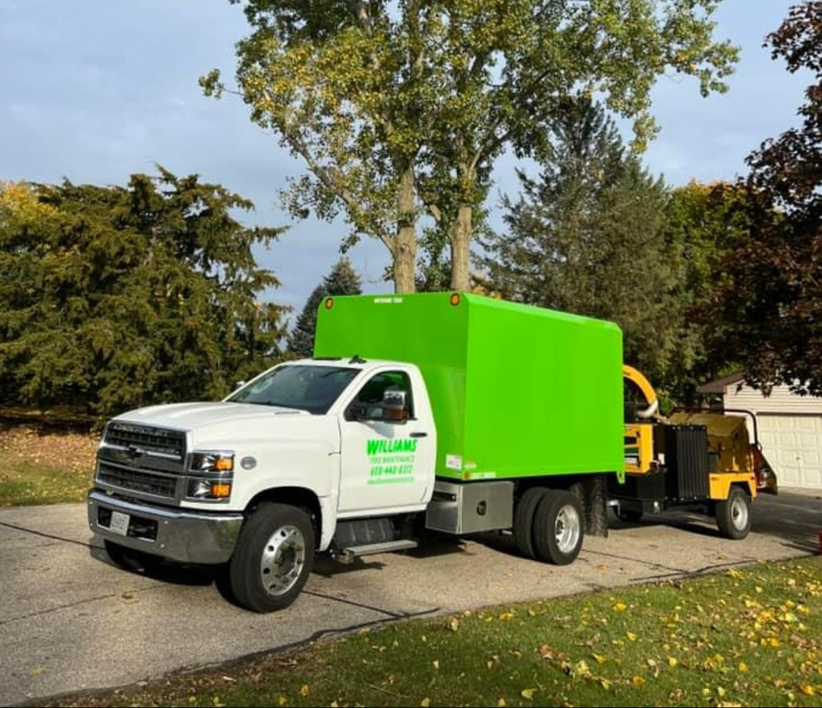 A white truck with a green box on the back of it