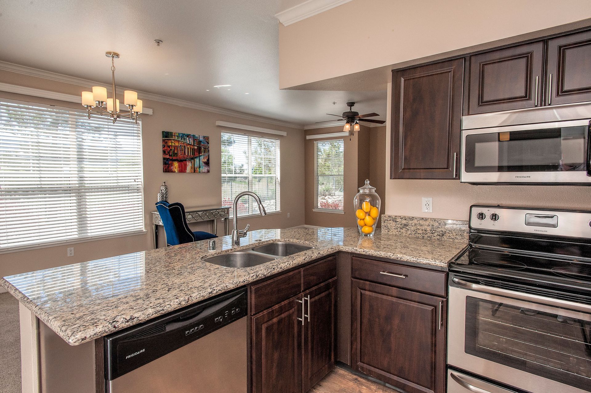 Kitchen with granite countertops, dark wood cabinets, and stainless steel appliances.