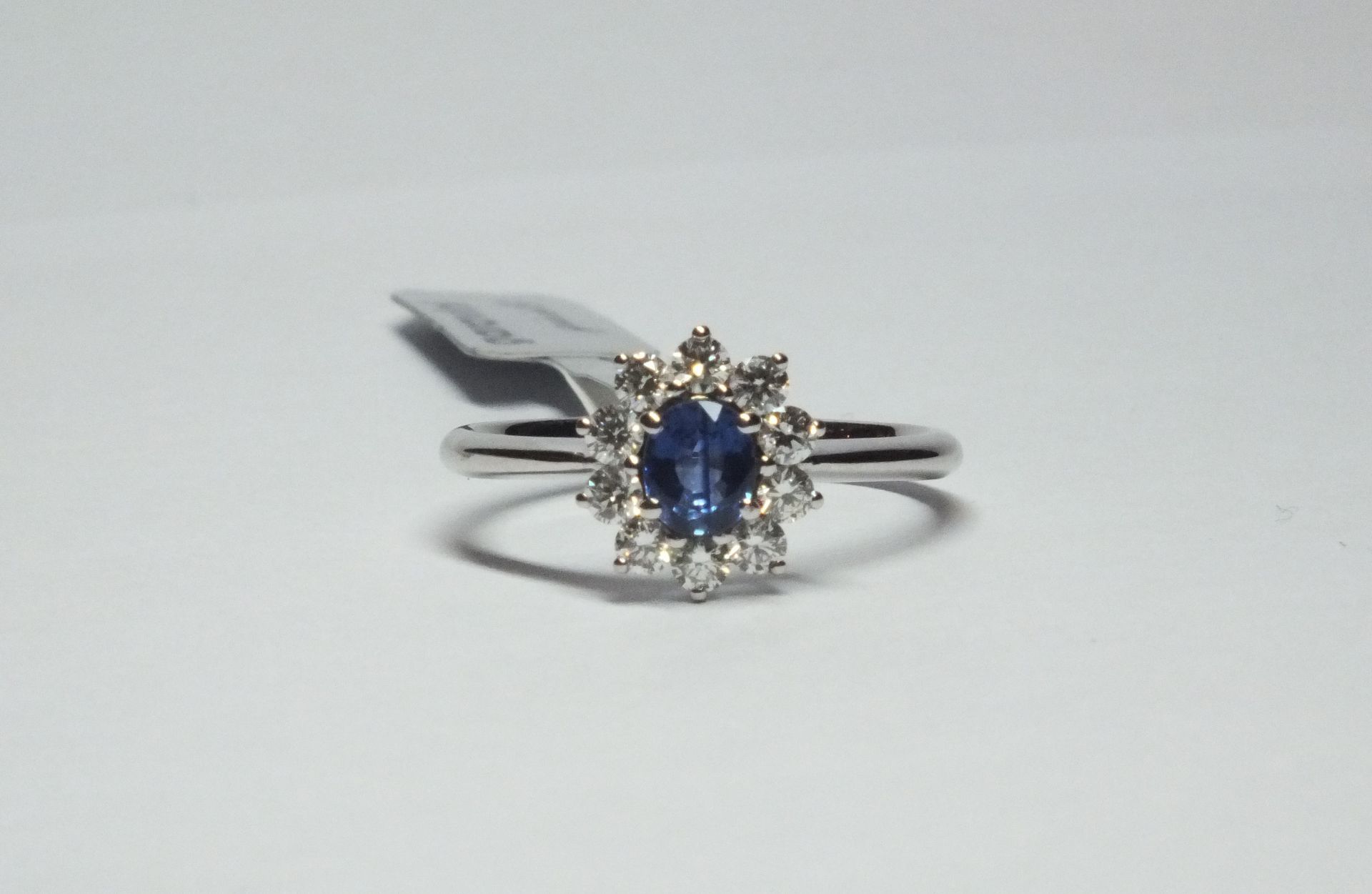 Un anello in oro bianco con una pietra blu e diamanti