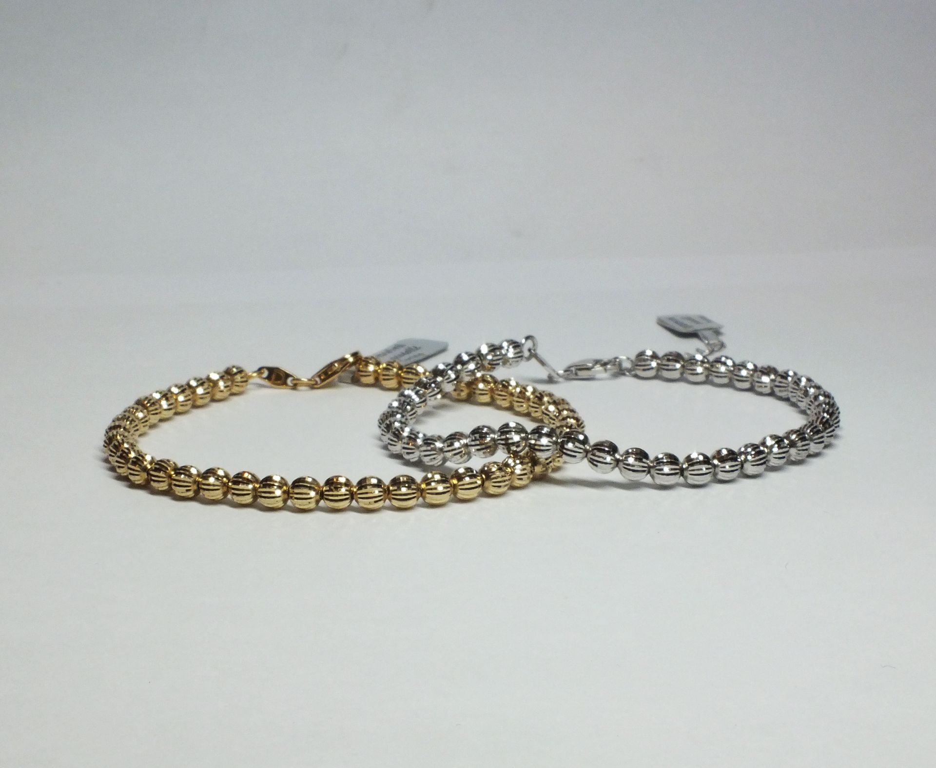 Due braccialetti sono impilati uno sopra l'altro su una superficie bianca
