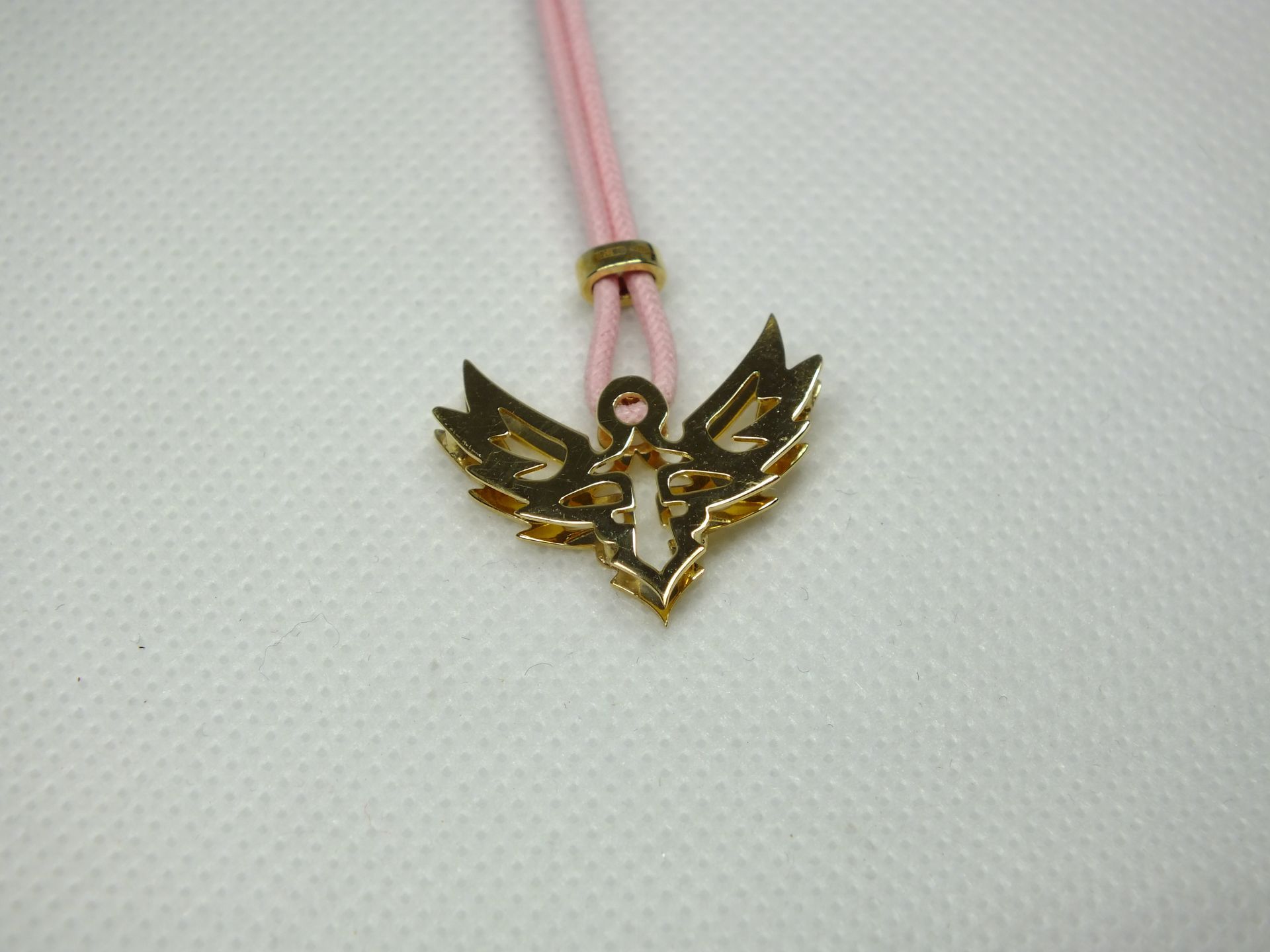 Una corda rosa con un ciondolo d'oro