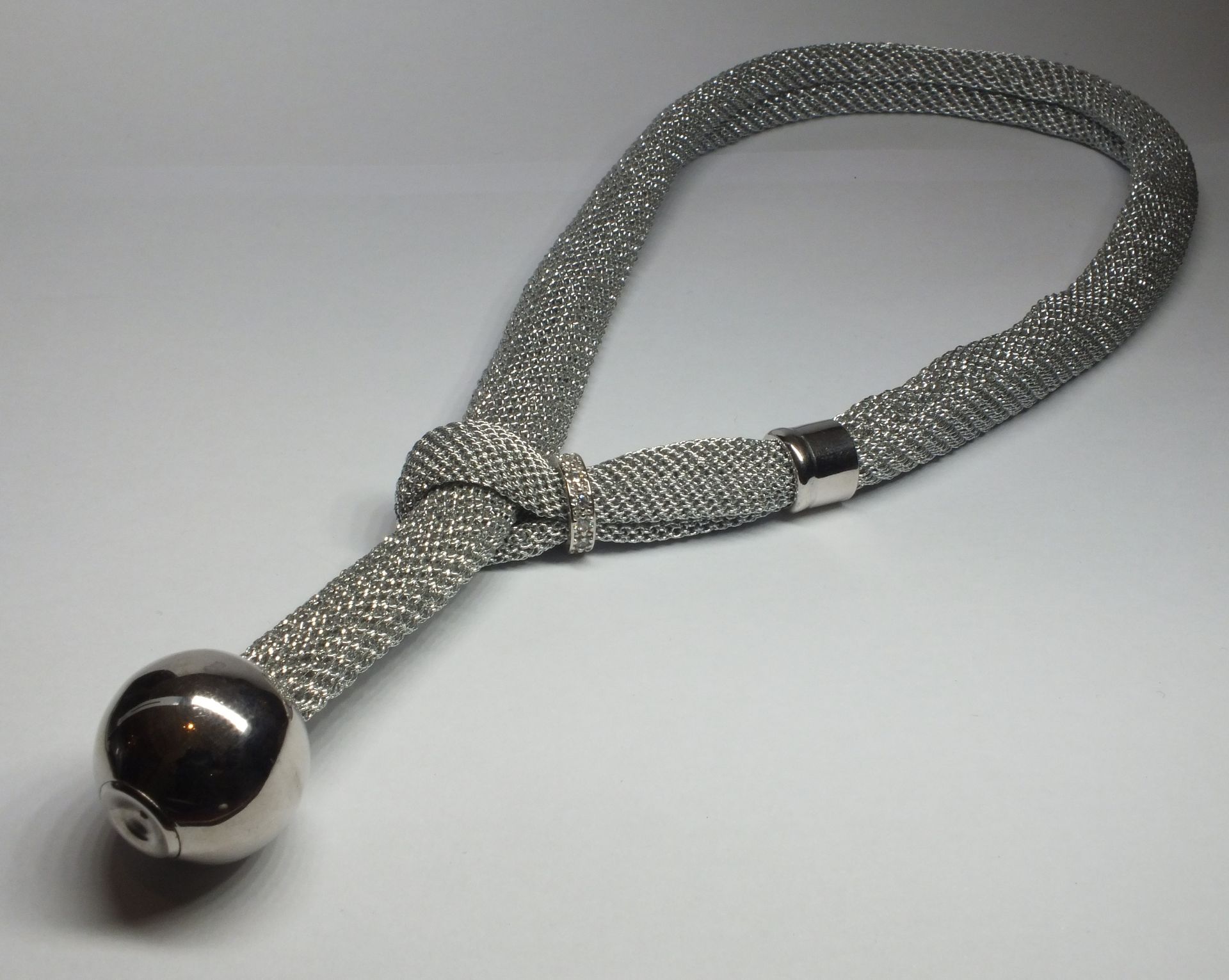 Una collana d'argento con una pallina d'argento all'estremità