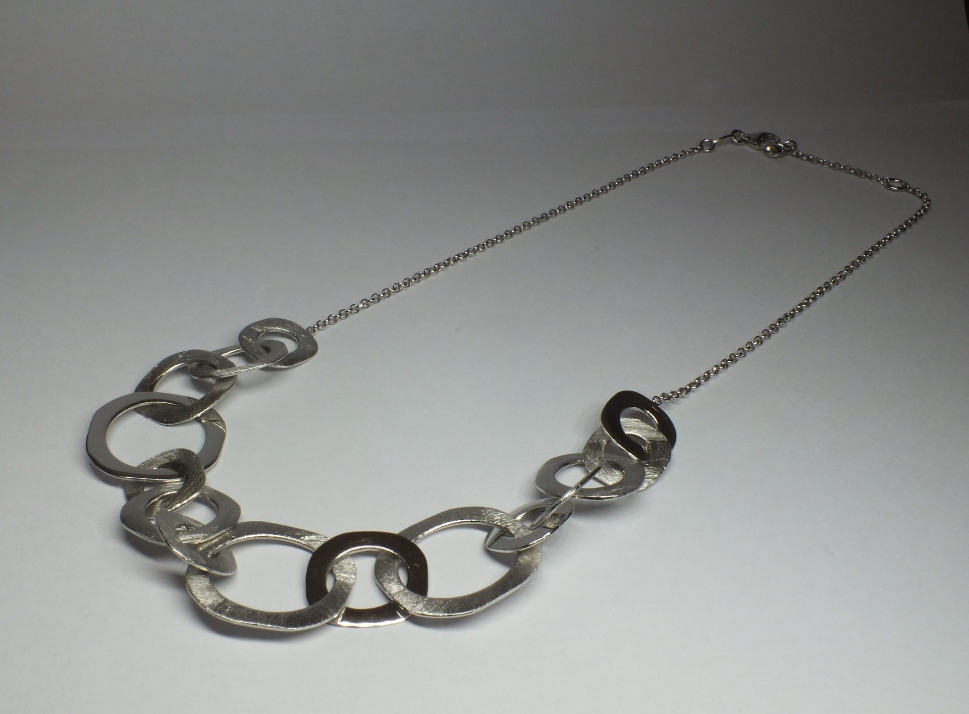 Una collana a catena d'argento con dei cerchi sopra