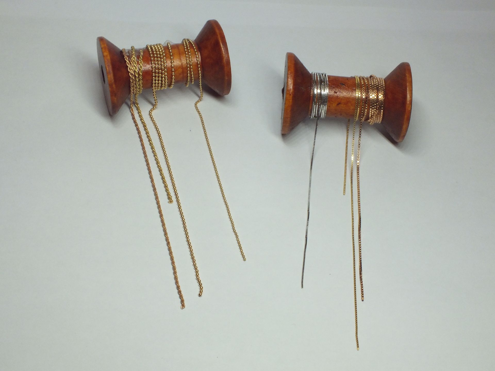 Due rocchetti di legno con catene d'oro attaccate