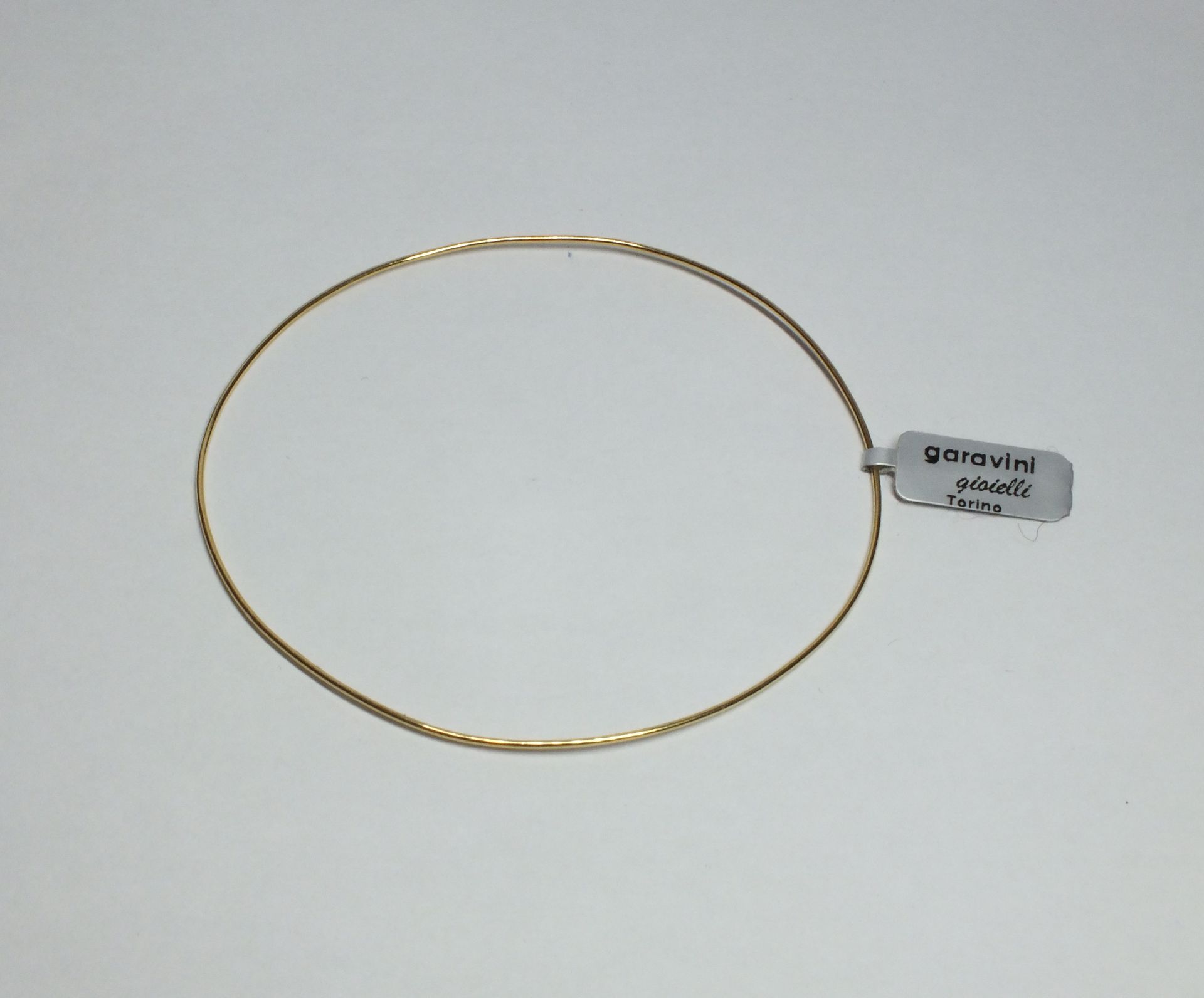 Un braccialetto d'oro con un'etichetta che dice 