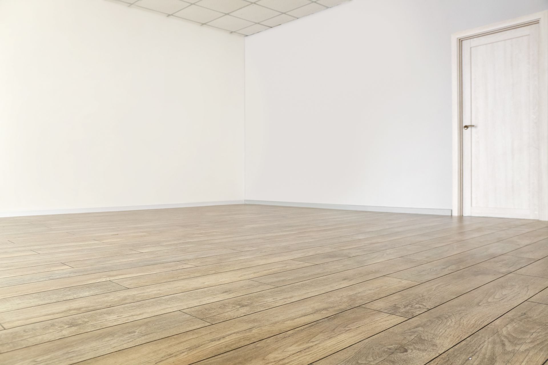 an empty room with a wooden floor and white walls .