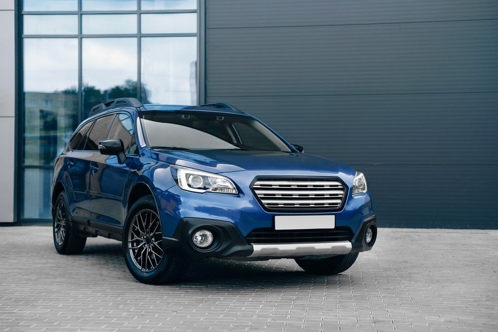 A Blue Subaru Outback Is Parked In Front Of A Building — Downsy's Cars In Bentley Park, QLD