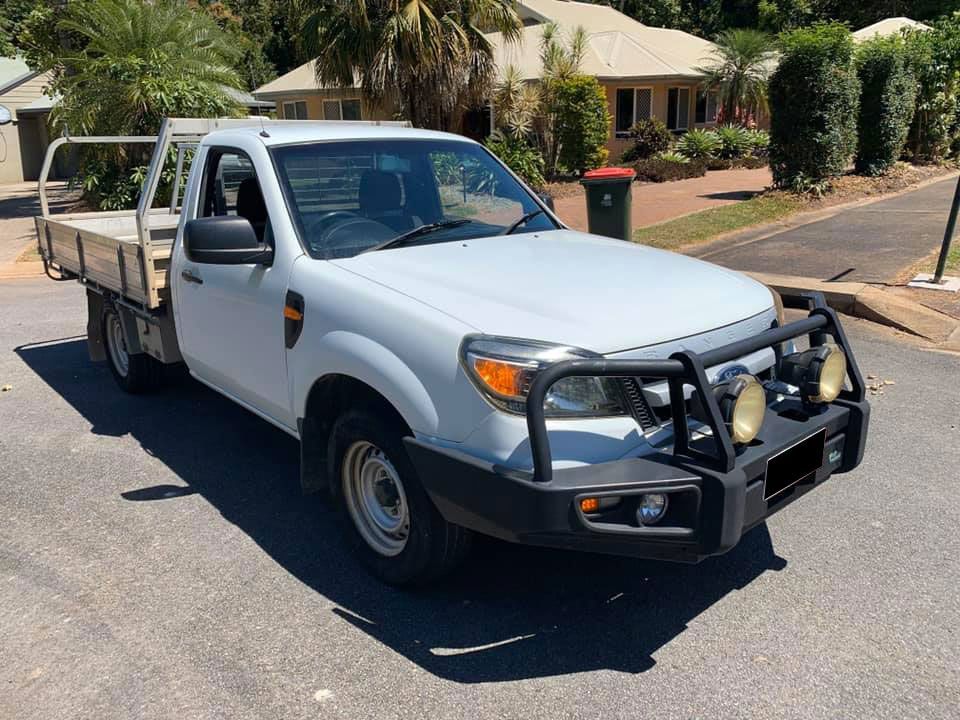 A White Truck Is Parked On The Side Of The Road In Front Of A House — Downsy's Cars In Bentley Park, QLD
