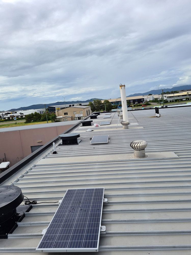 Solar Panels Are Sitting On The Roof Of A Building — Insulation In Mount Louisa, QLD
