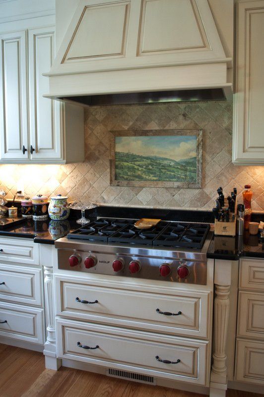 A kitchen with a stove top oven and a painting on the wall above it