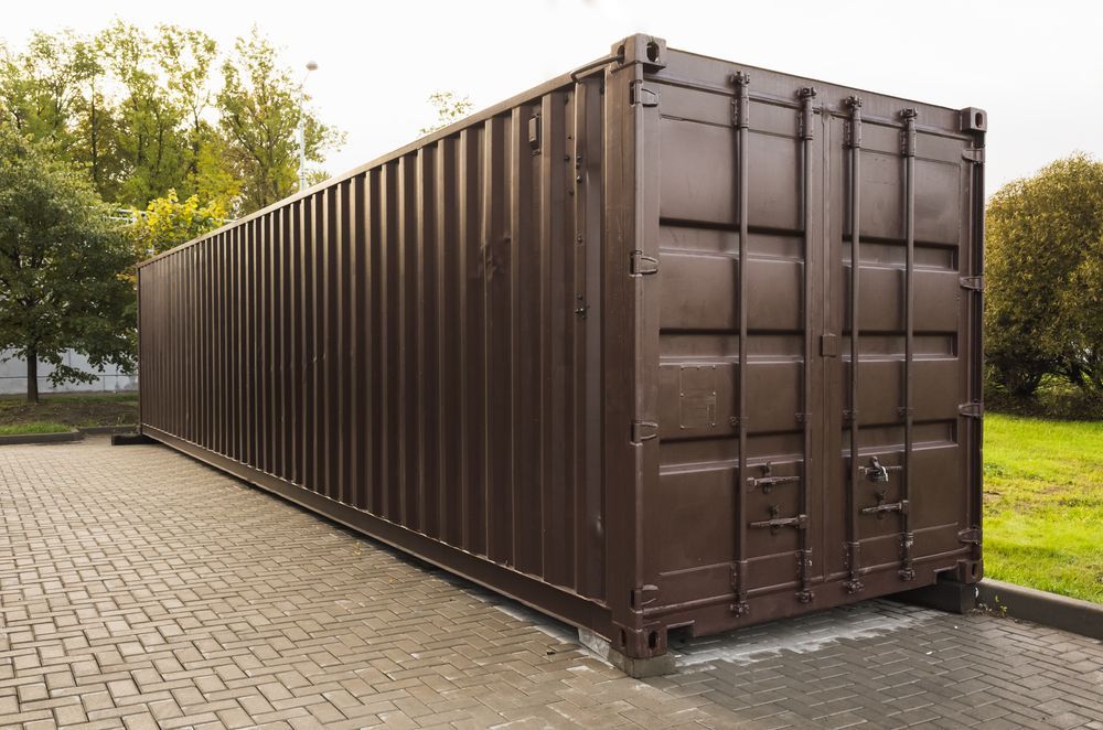 Brown Shipping Container on a Paved Area, in a Park-like Setting — Gantic Removals & Storage in Tivoli, QLD