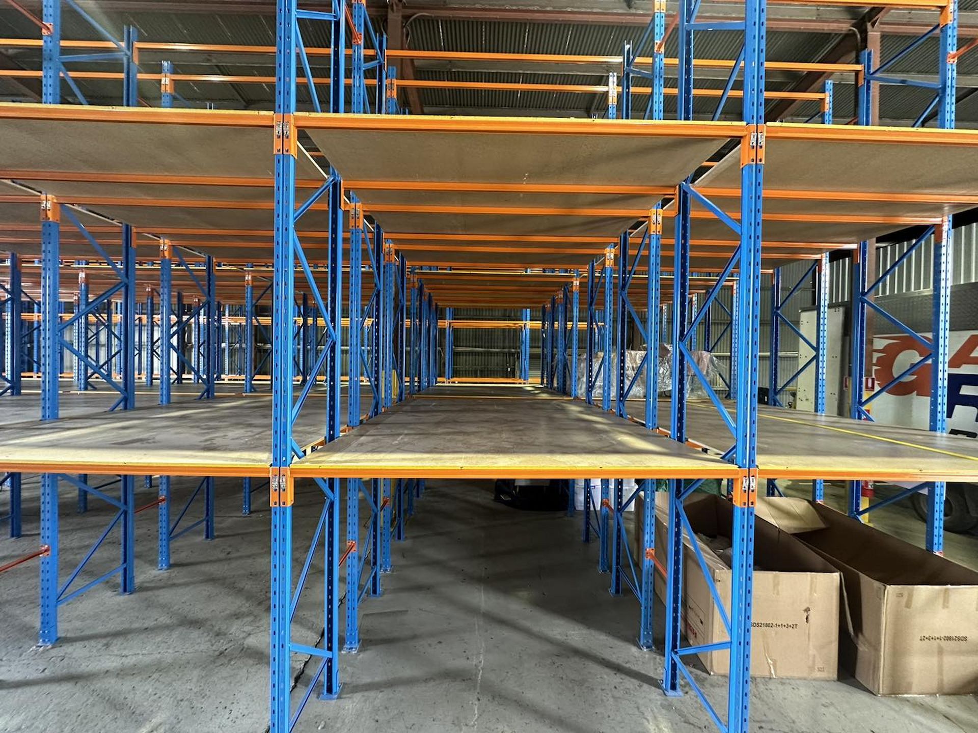Warehouse Interior With Blue Shelving Units and Wood Platforms — Gantic Removals & Storage in Logan, QLD