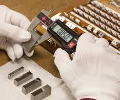 A person is measuring a piece of wood with a ruler and pencil.