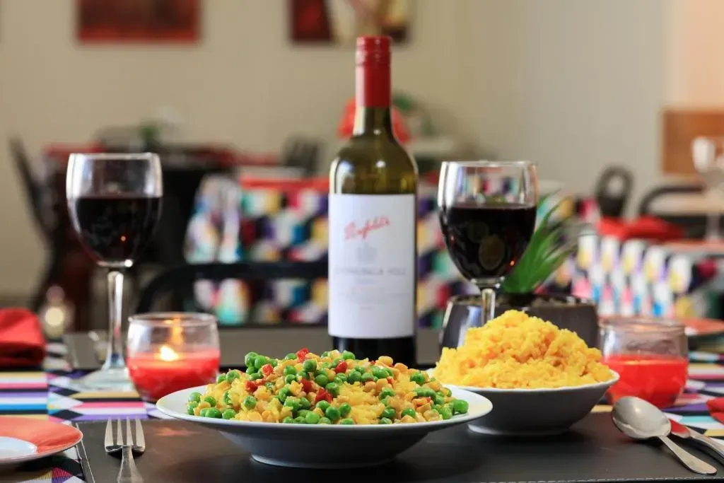 Table Setting with Wine, Food, Candles, and Colorful Tablecloth — Townview Motel In Mount Isa, QLD