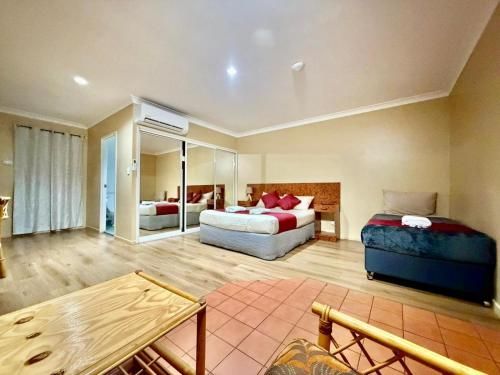 Bathroom with A White Toilet, Sink, and Bathtub with Teal Tiles — Townview Motel In Mount Isa, QLD
