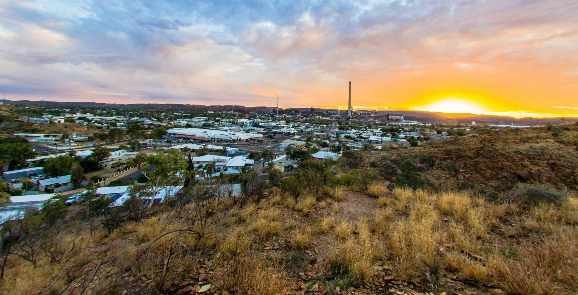 Town at Sunset with Colorful Sky and Dry Brush in The Foreground — Townview Motel In Mount Isa, QLD