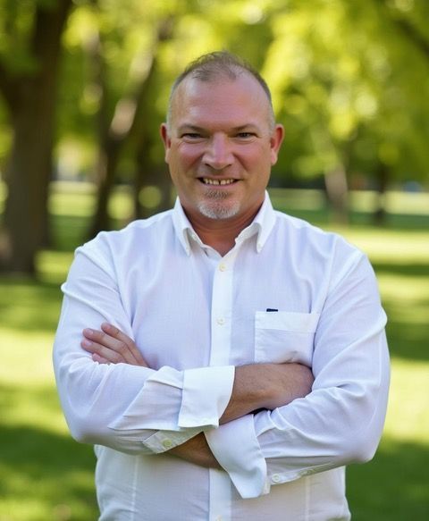 A man in a white shirt with his arms crossed