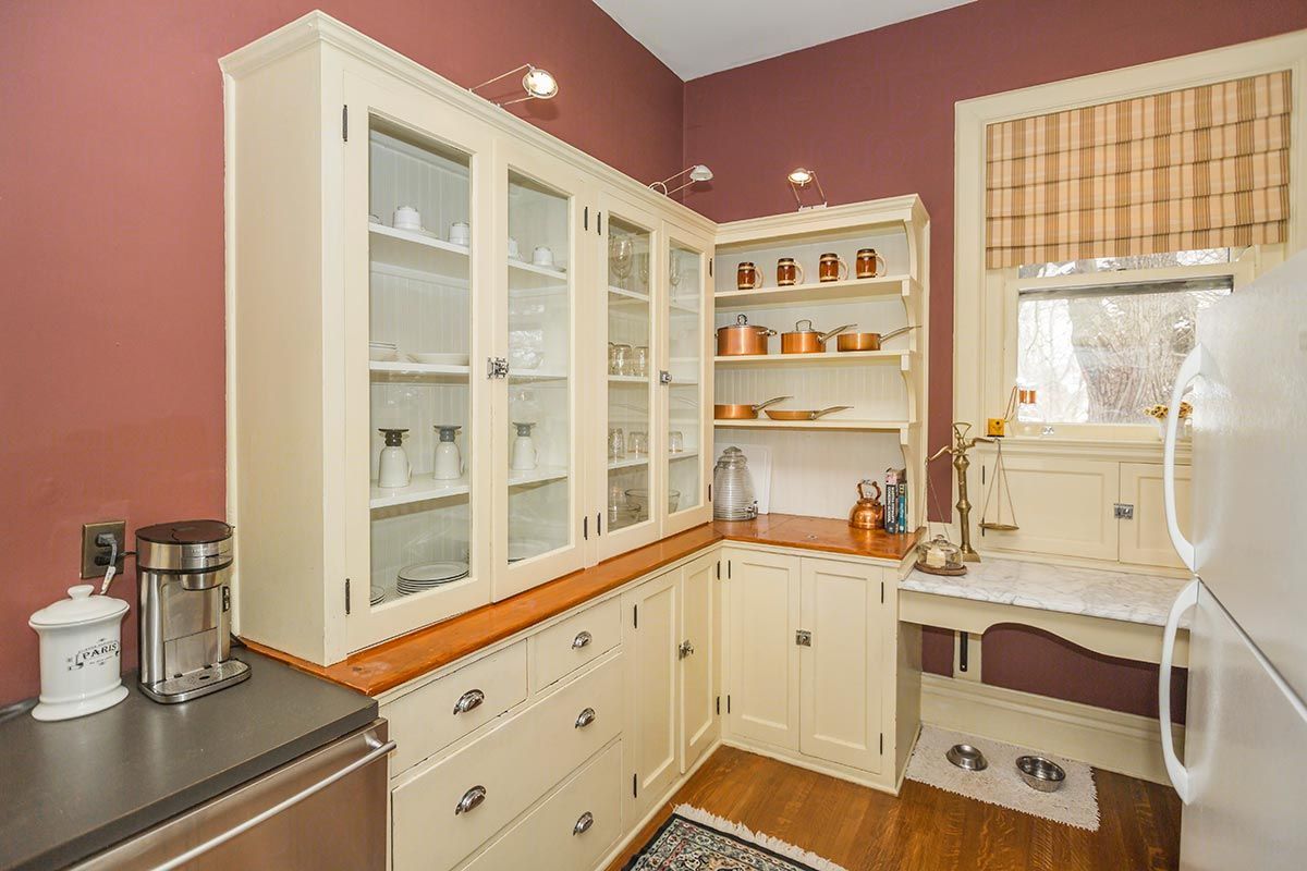 A kitchen with white cabinets and a white refrigerator.