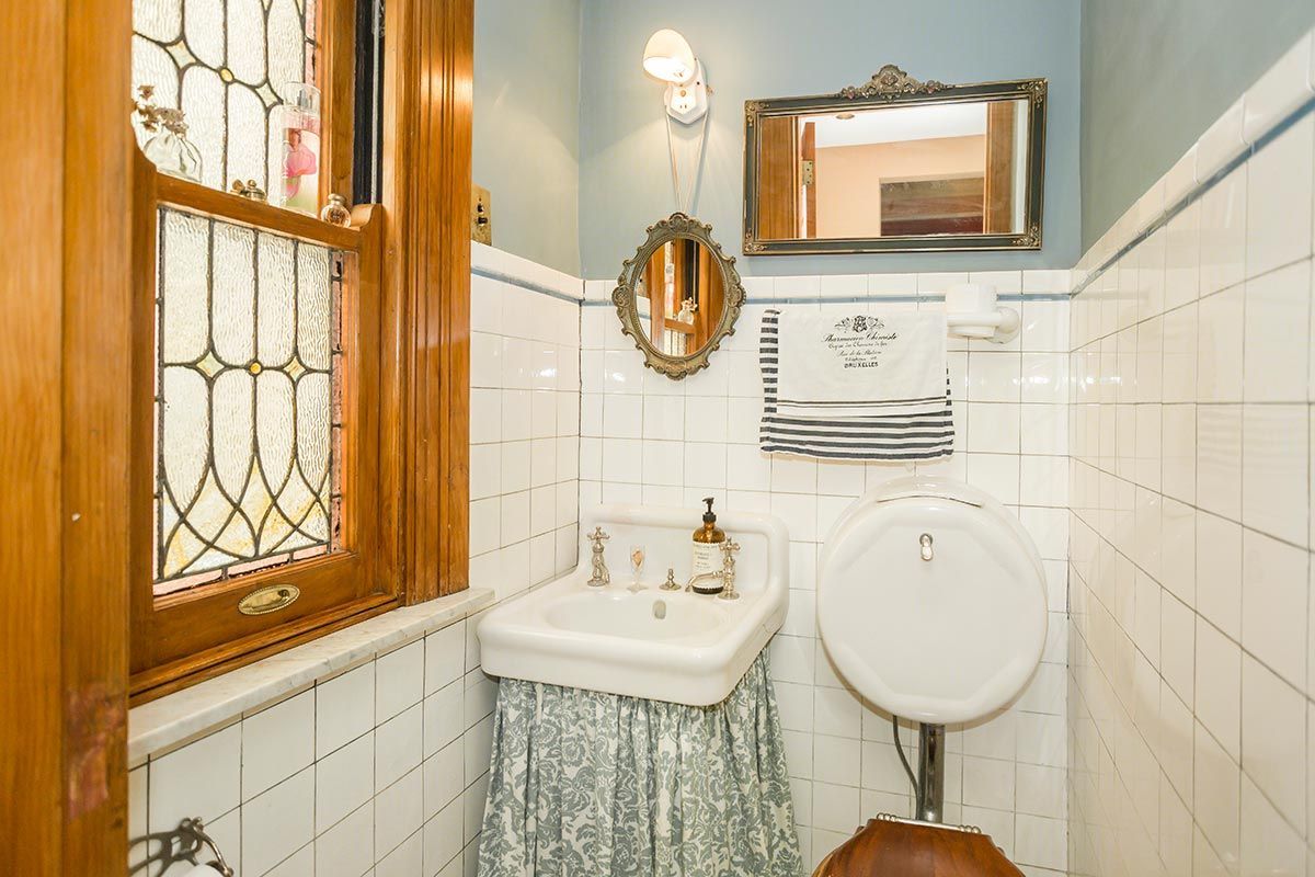A bathroom with a sink , mirror and window