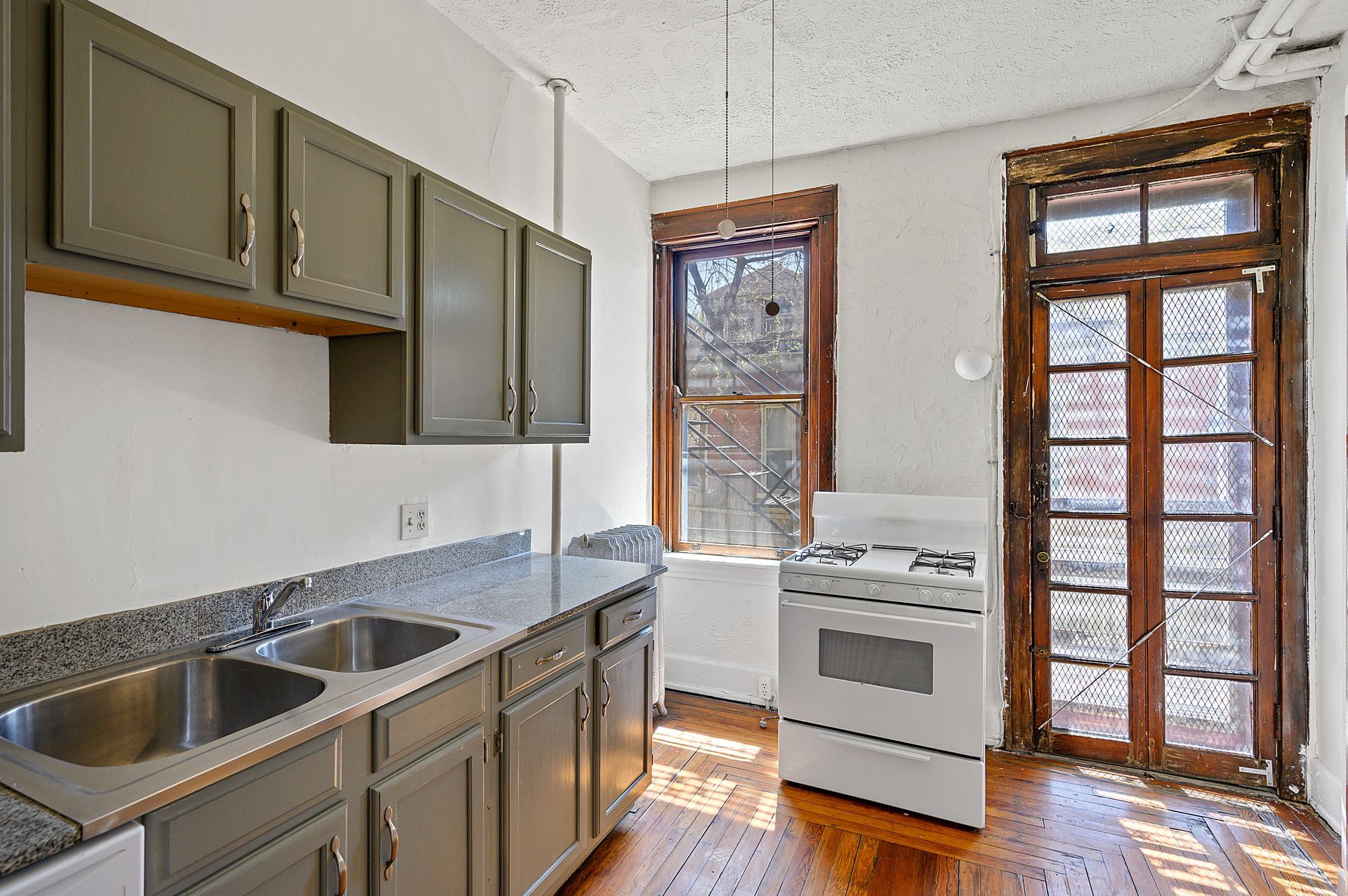 An empty kitchen with two sinks and a stove